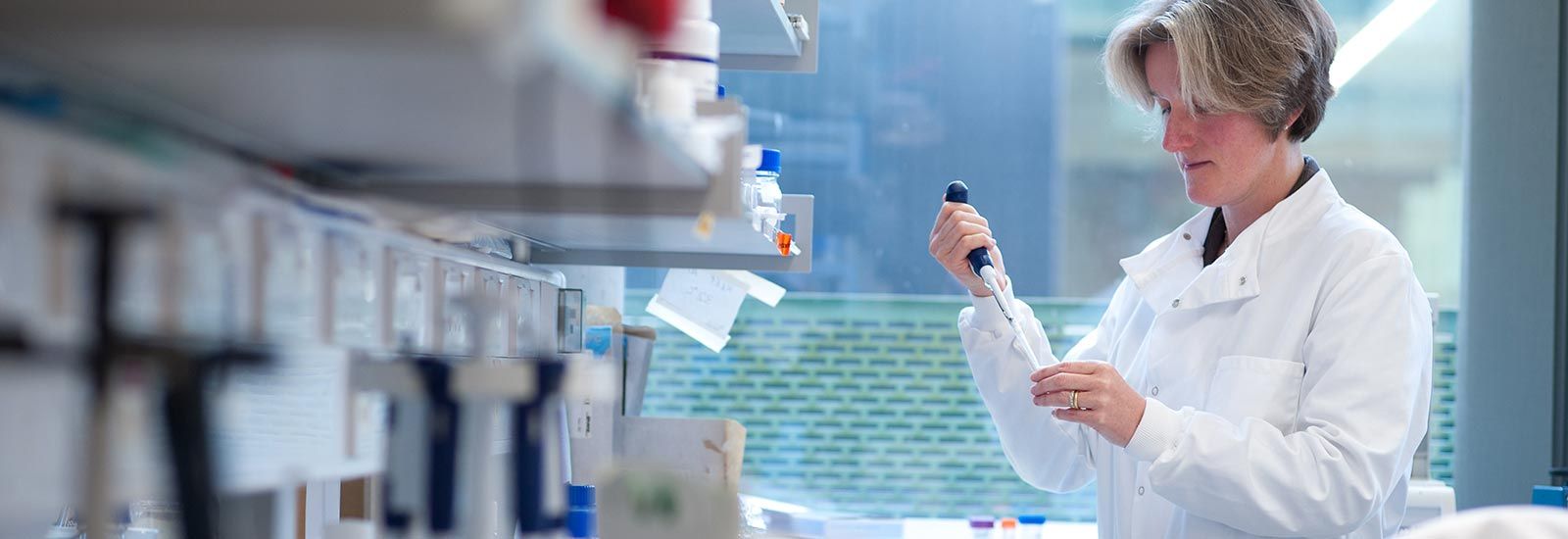 A tutor in a lab coat in an Old Road Campus lab